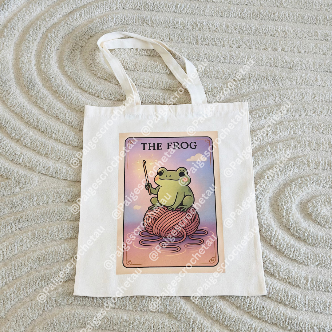 Whimsical Frog crochet tote bag with pastel cloud artwork, ideal for carrying yarn, hooks, and WIP projects