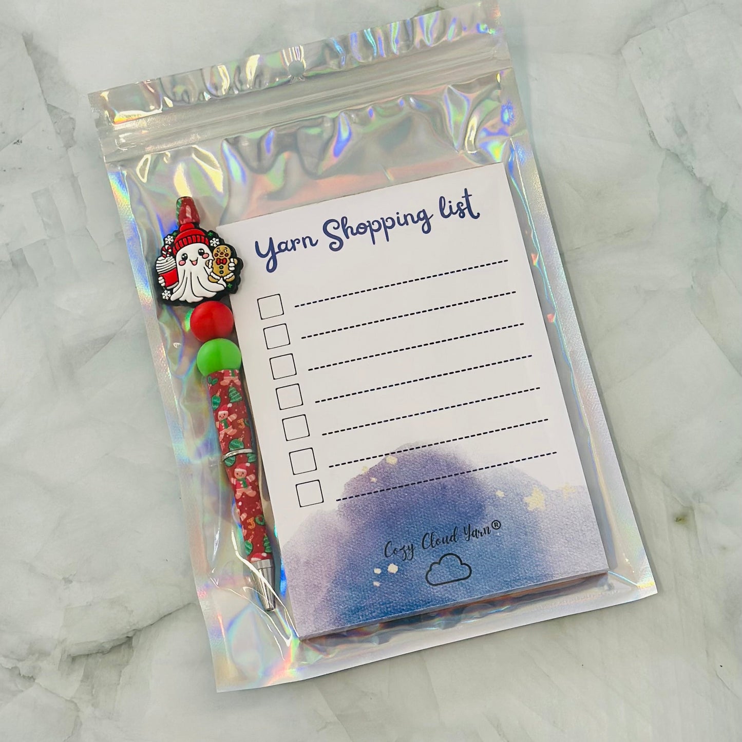Yarn shopping list with a gnome design on a marble surface