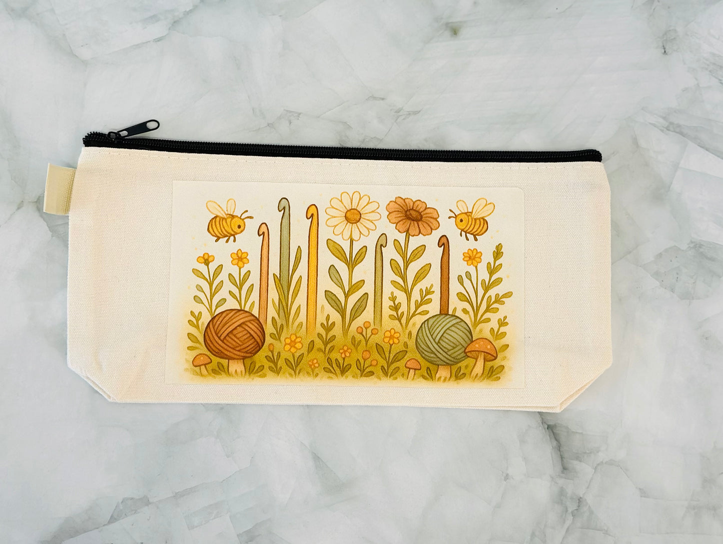 Canvas pouch with floral and bee design on a marble background