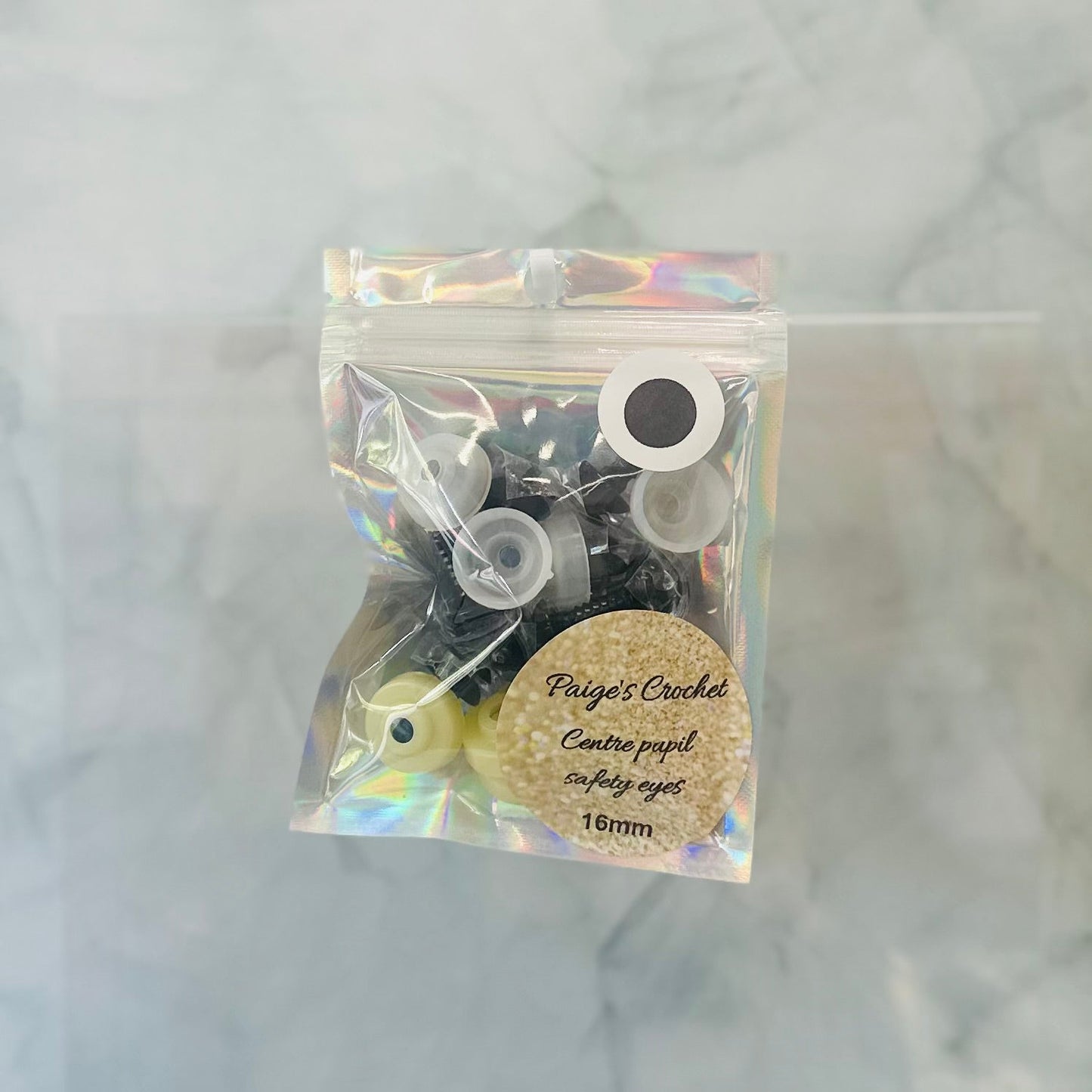 Packaged safety eyes with a label on a marble background