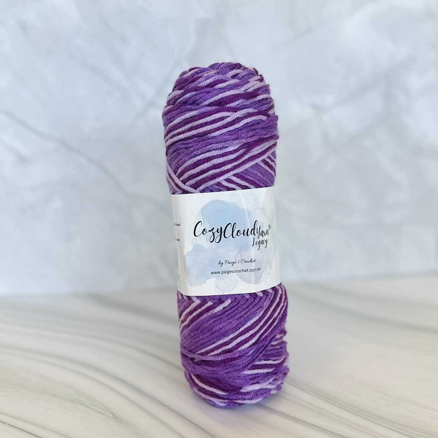 Purple skein of yarn with a label on a white background