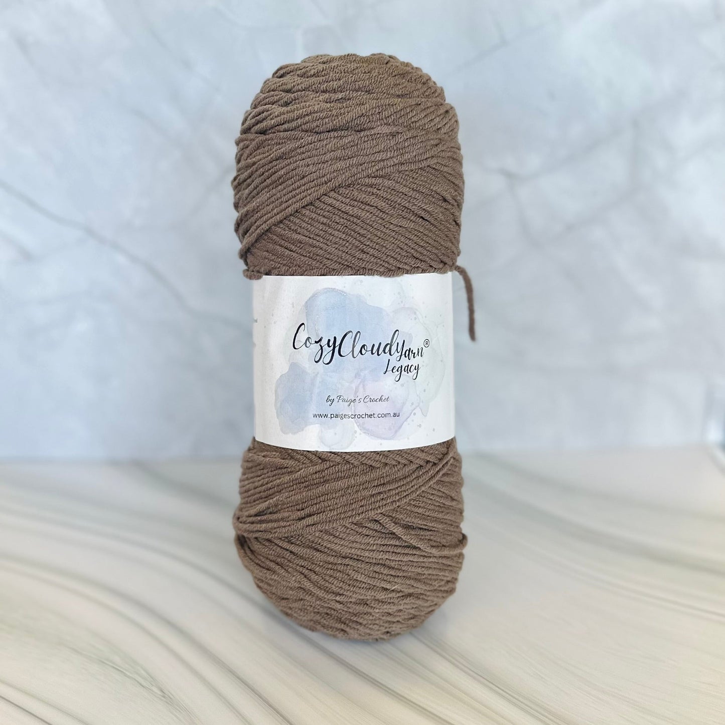 Ball of brown yarn with a label on a white background