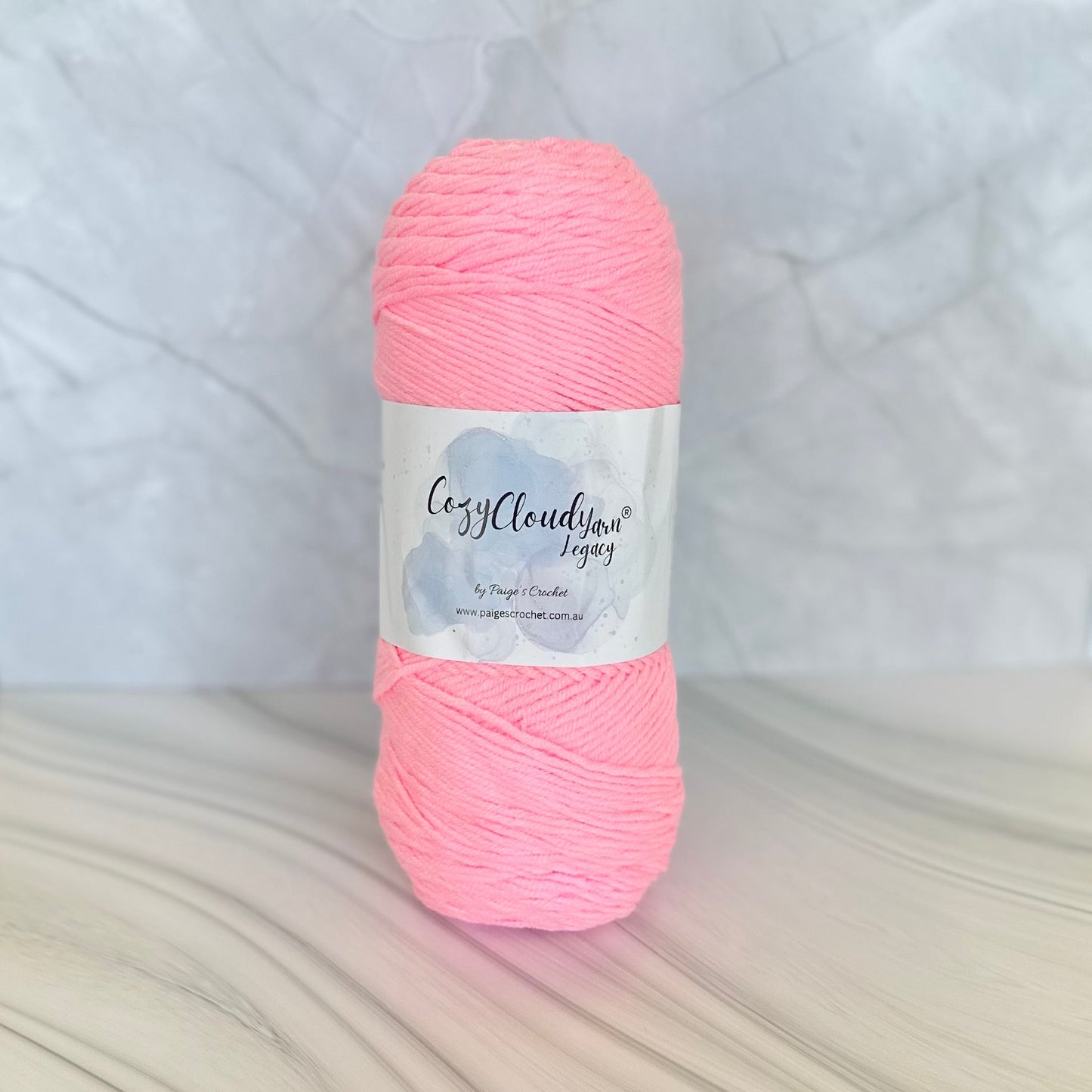 Pink yarn ball with a label on a textured white background