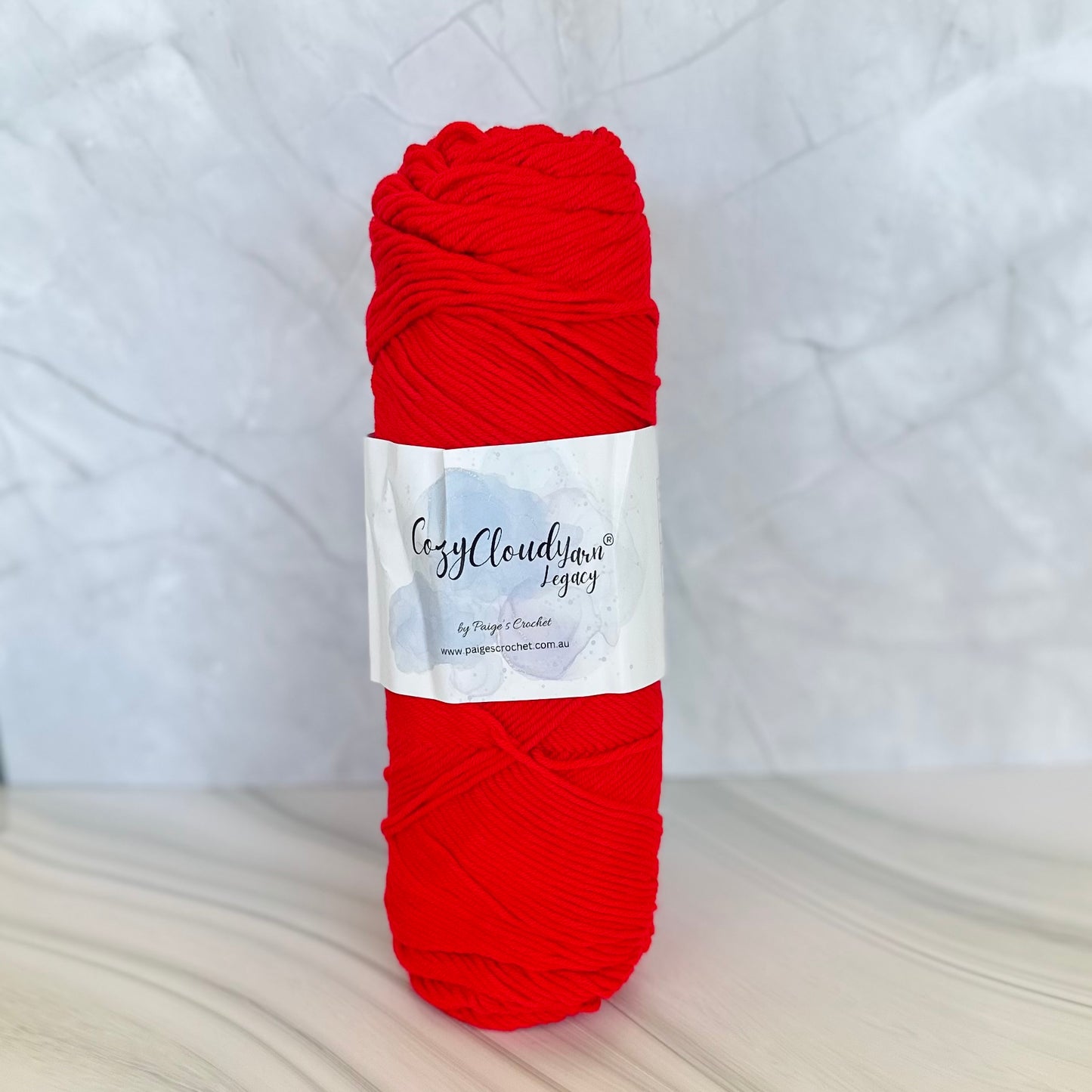 Red skein of yarn with a label on a white background