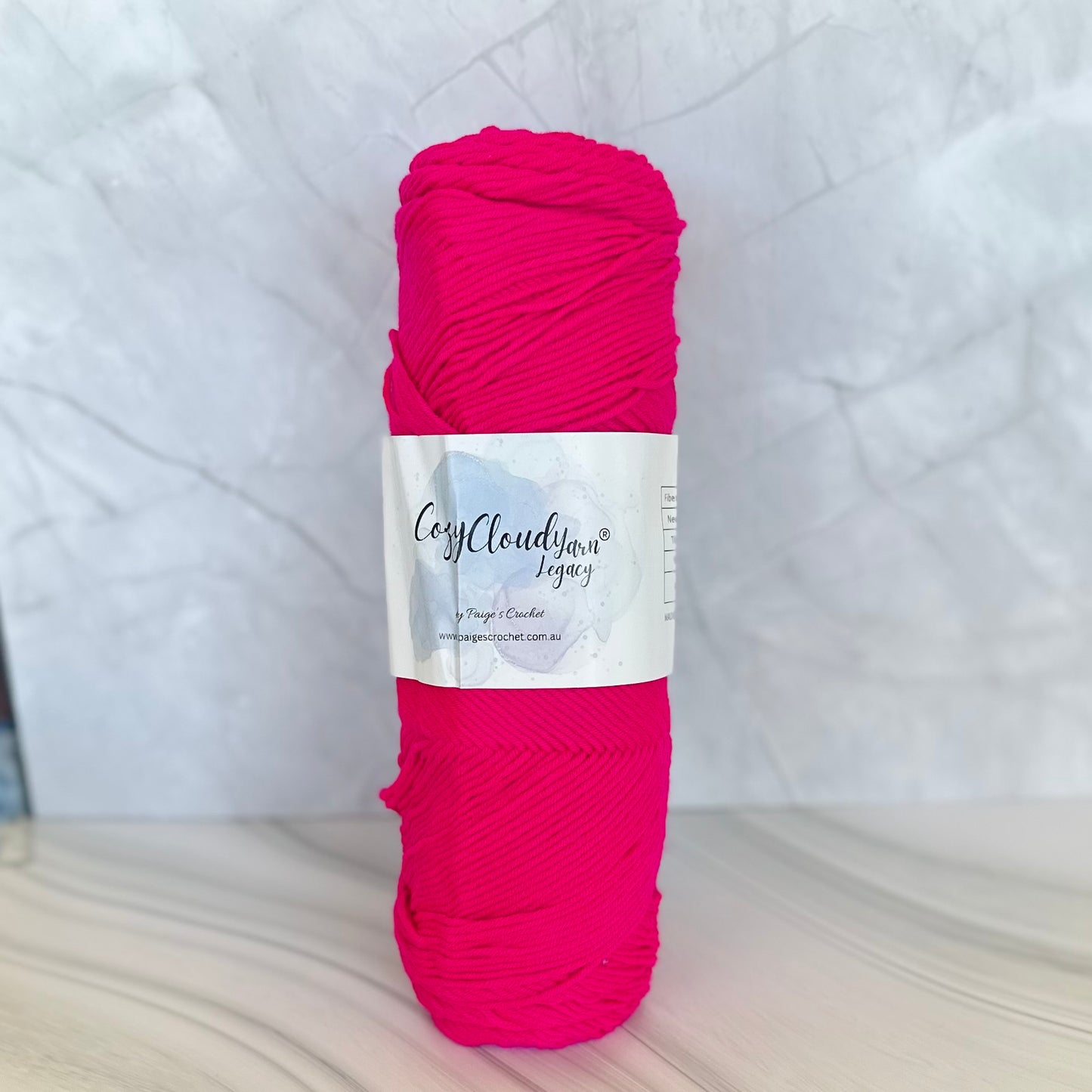 Ball of pink yarn with a label on a white background
