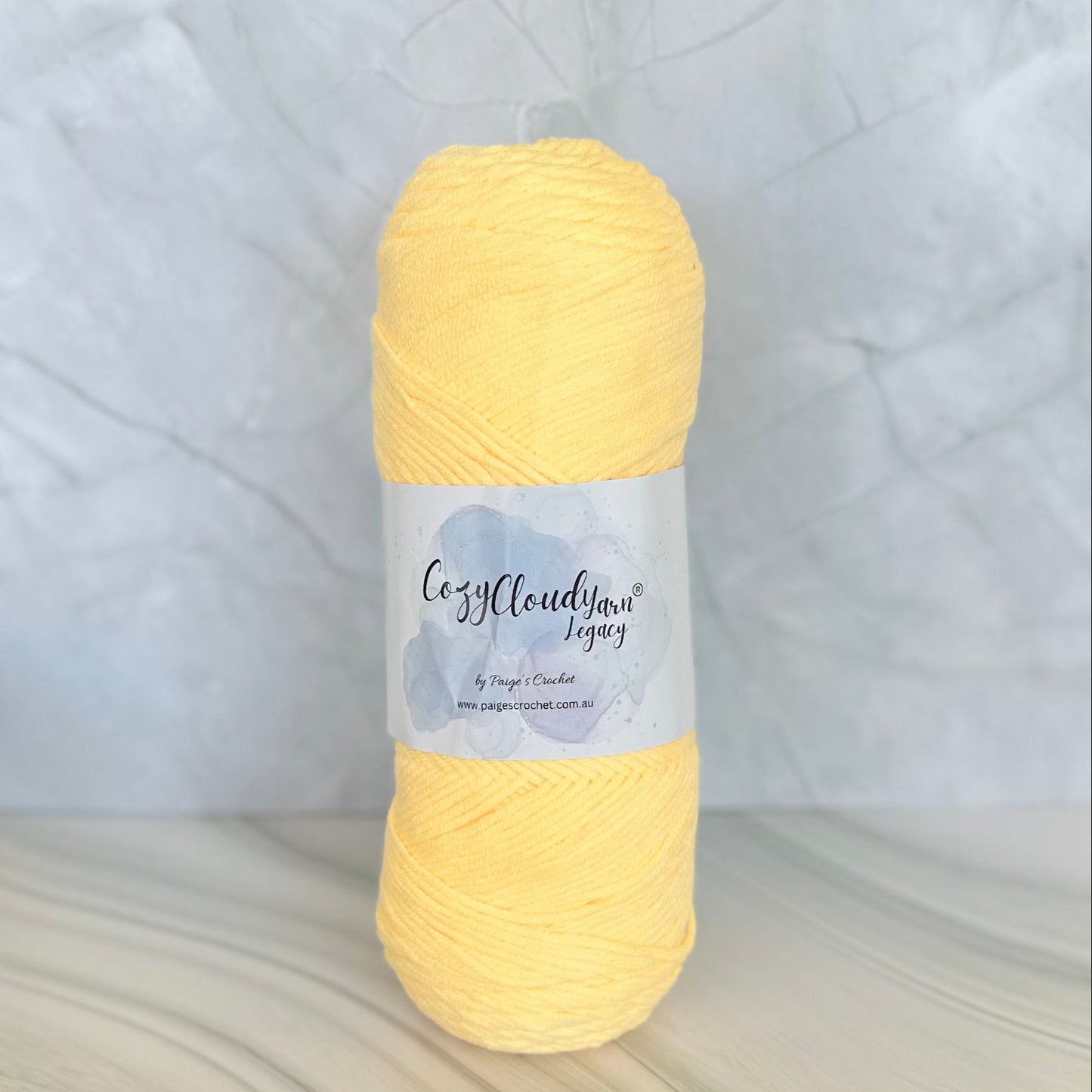 Yellow skein of yarn with a label on a textured surface