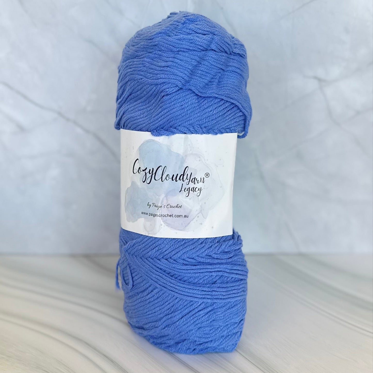 Blue skein of yarn with a label on a white background