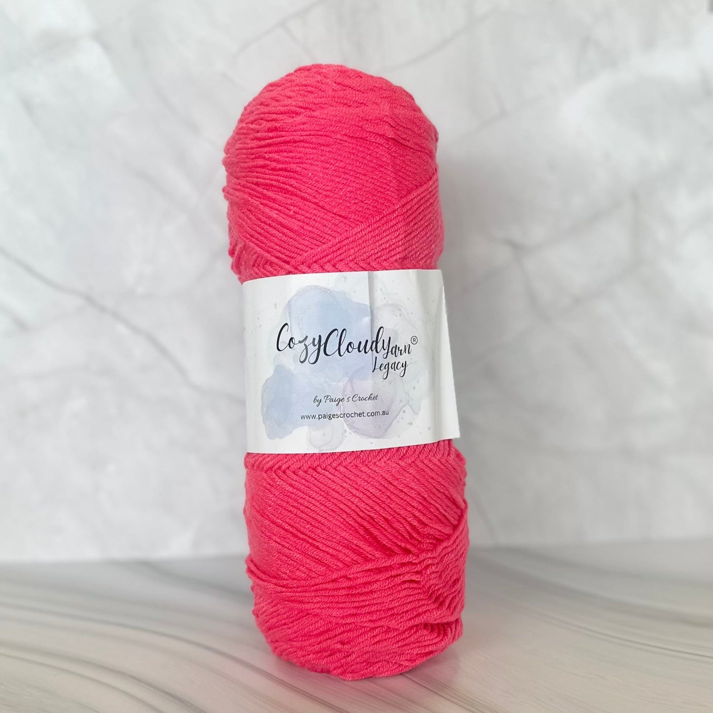 Ball of pink yarn with a label on a white background