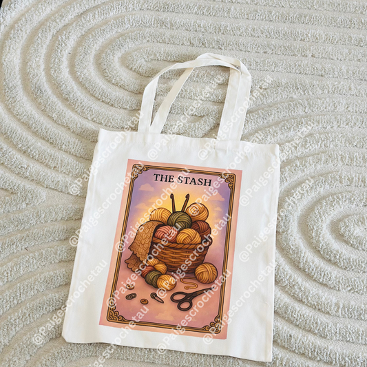 A tarot-inspired Cozy tote bag with soft, calming yarn artwork in warm pastel tones, DTF printed on a durable tote for crochet and yarn lovers