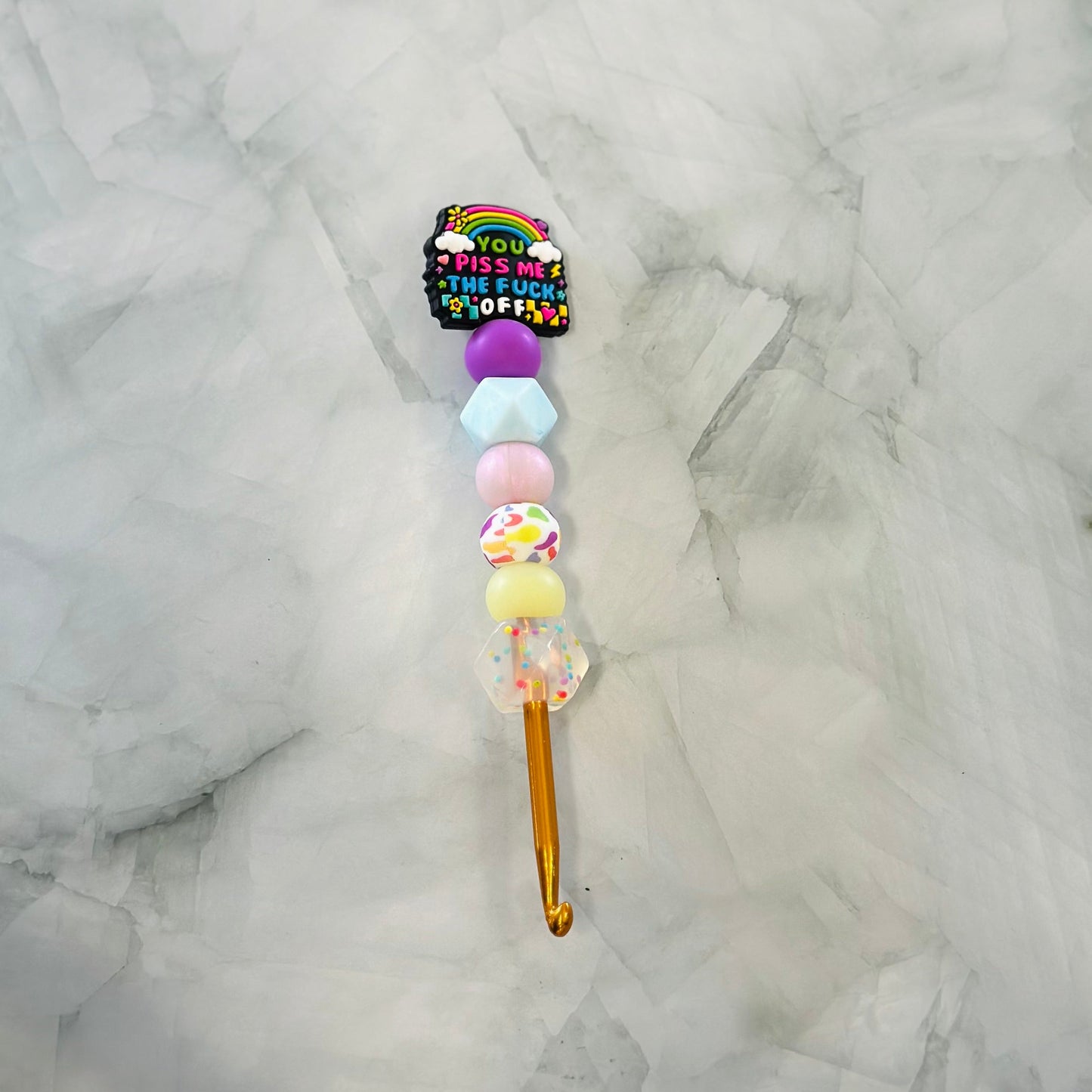 Decorative Crochet hook with colorful beads and a rainbow design on a marble background - best used with chenille and plush yarn 
