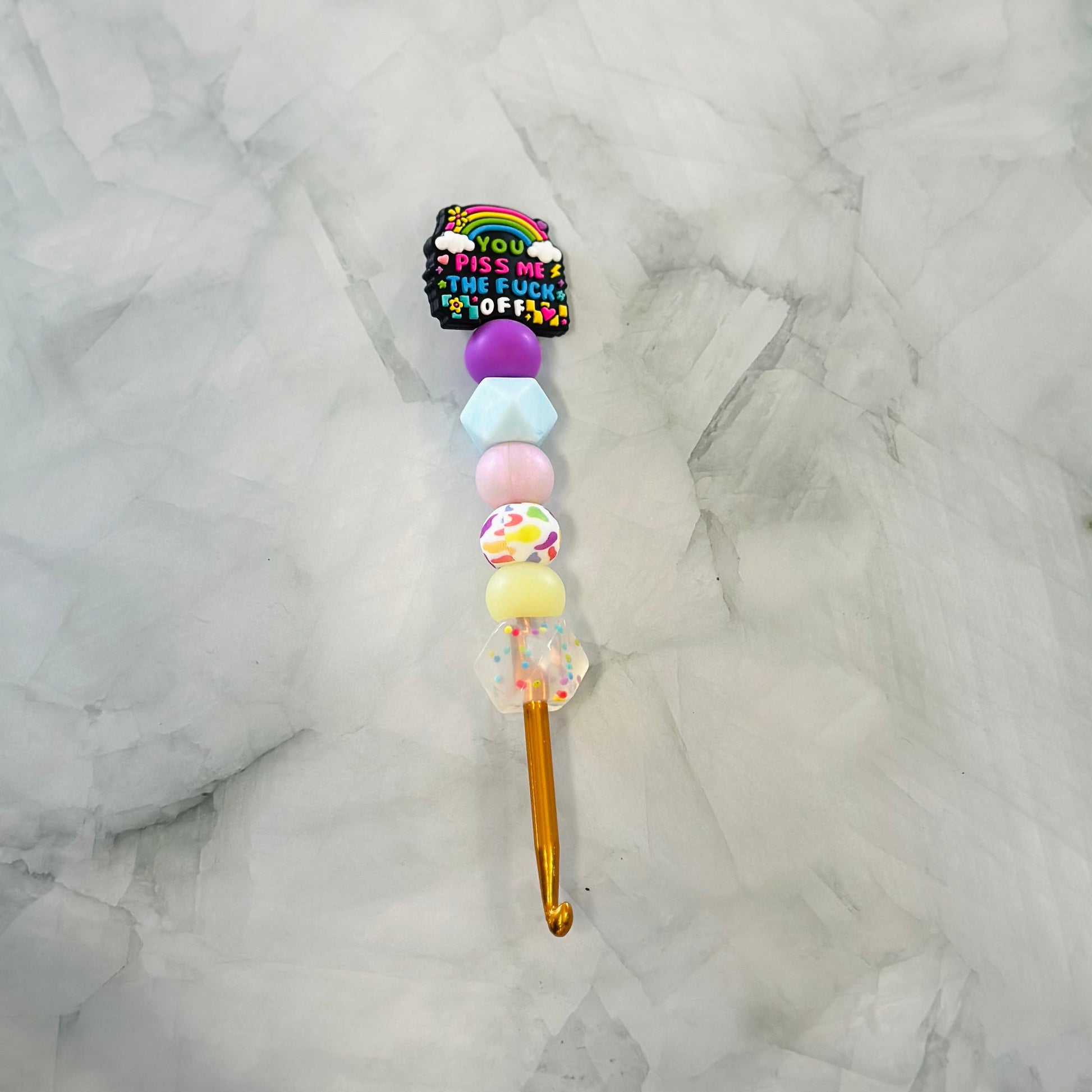 Decorative Crochet hook with colorful beads and a rainbow design on a marble background - best used with chenille and plush yarn 