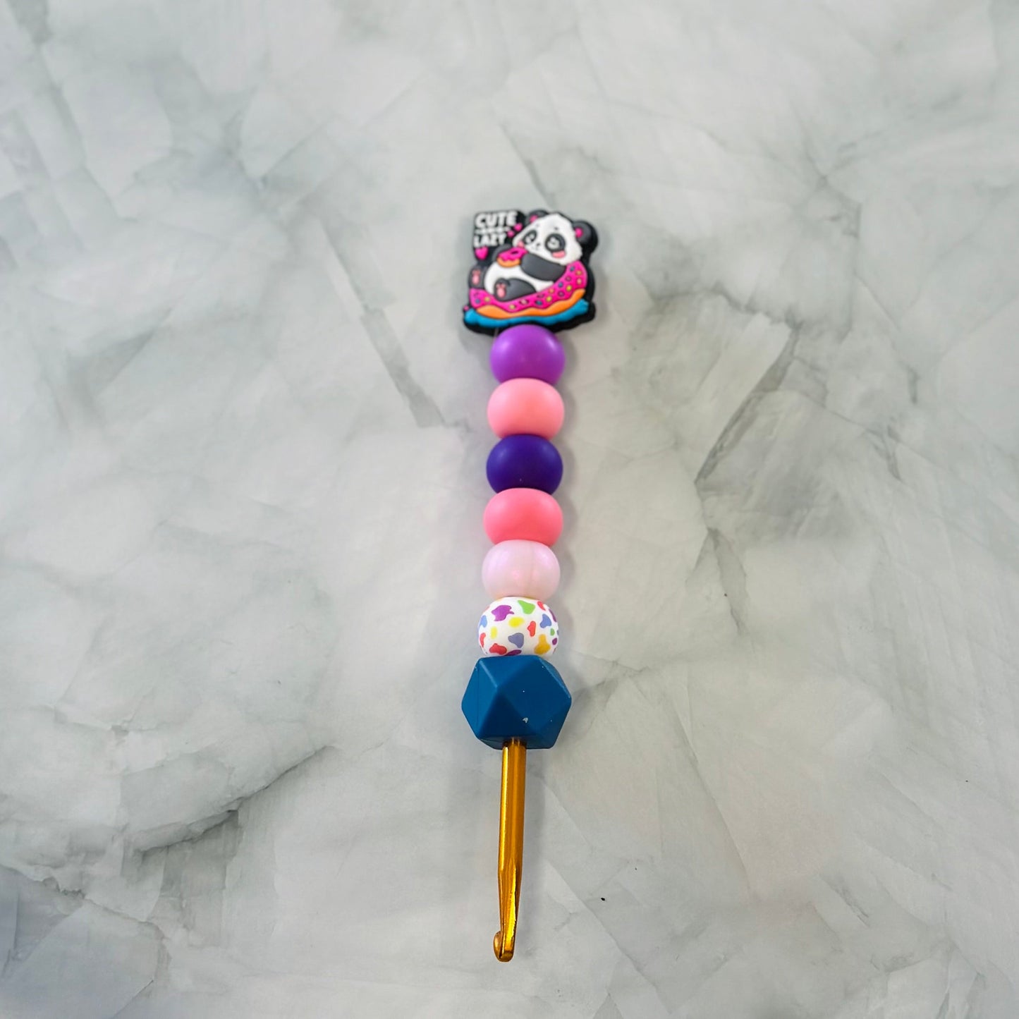Colorful beaded crochet hook with a panda charm on a marble background, chenille yarn, plush yarn 
