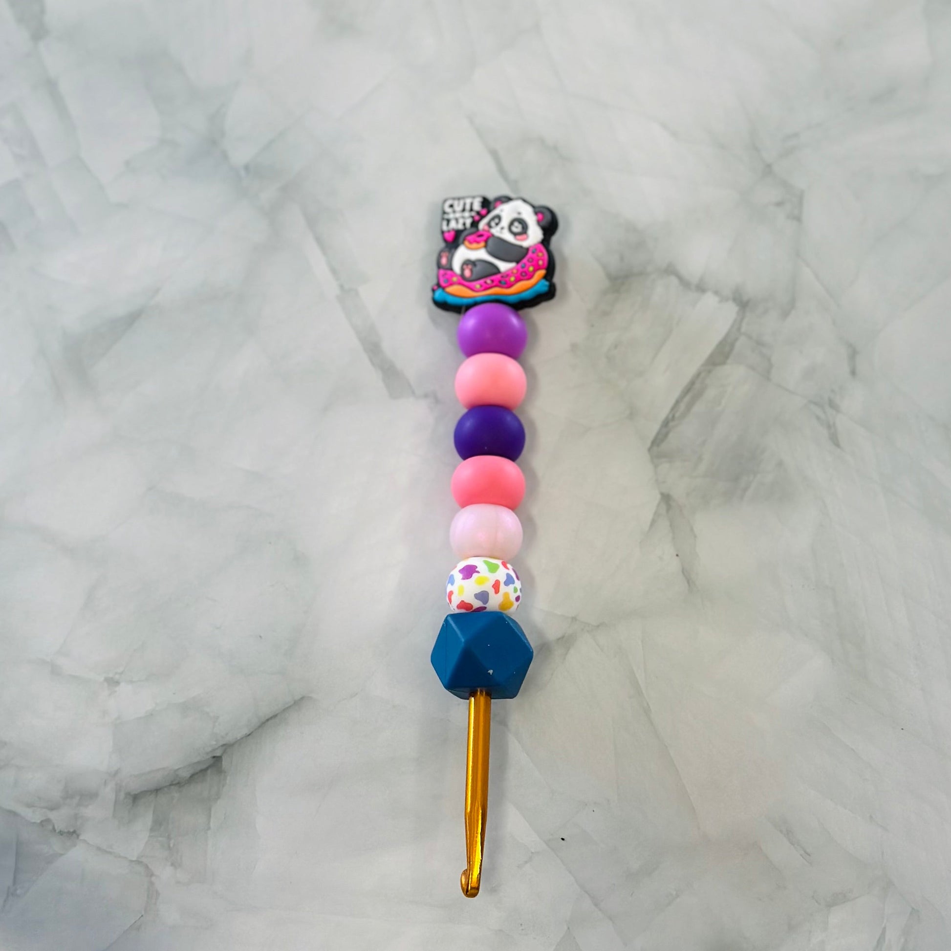 Colorful beaded crochet hook with a panda charm on a marble background, chenille yarn, plush yarn 