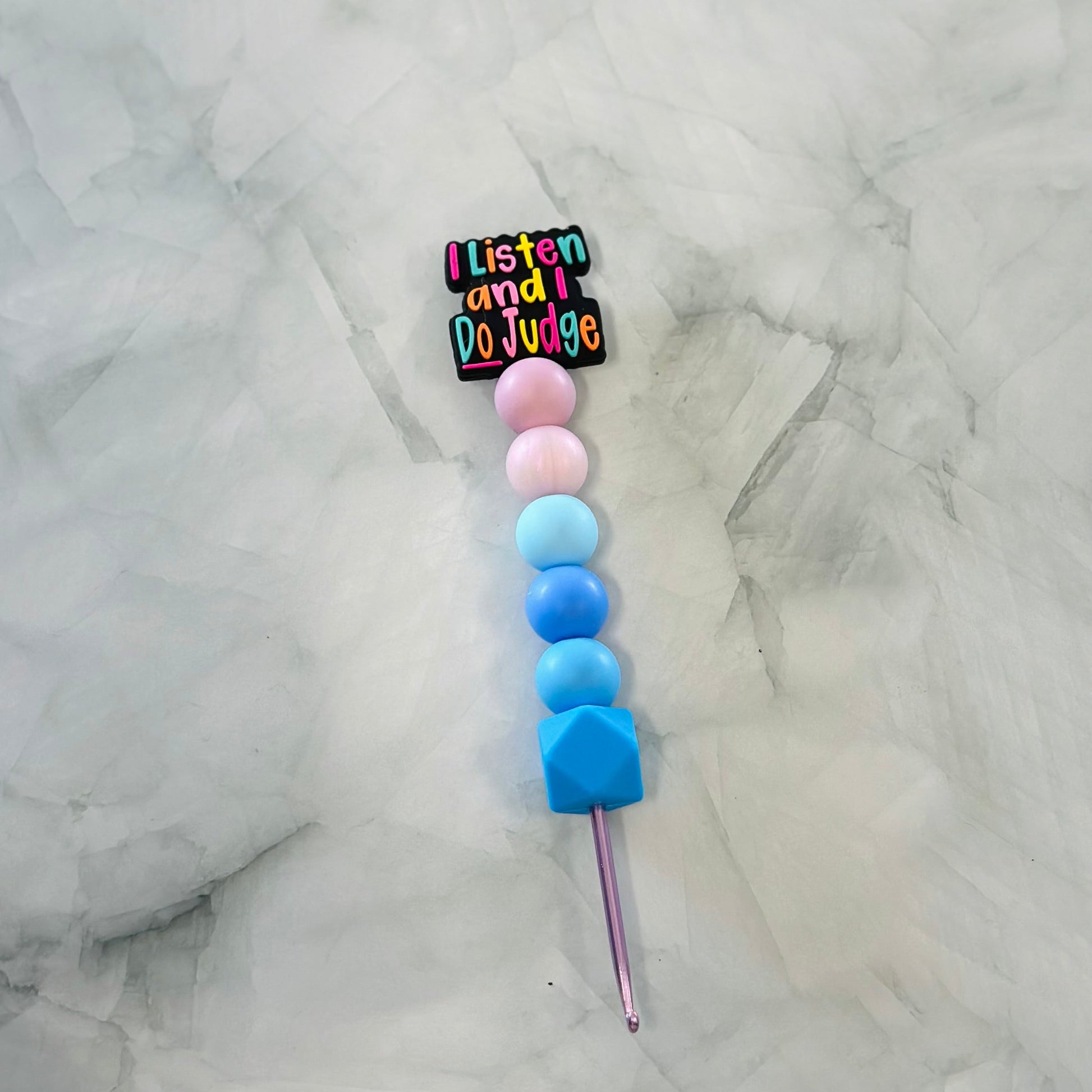 Colorful beaded crochet hook with a badge on a marble background, chenille yarn / plush yarn 