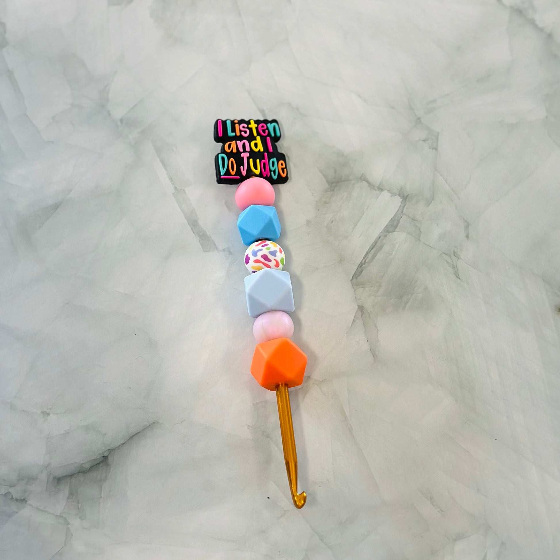 Colorful beaded  crochet hook with a phrase bead  on a textured white background, Best for use with chenille yarn 