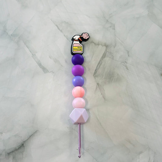 Colorful beaded crochet hook on a marble background