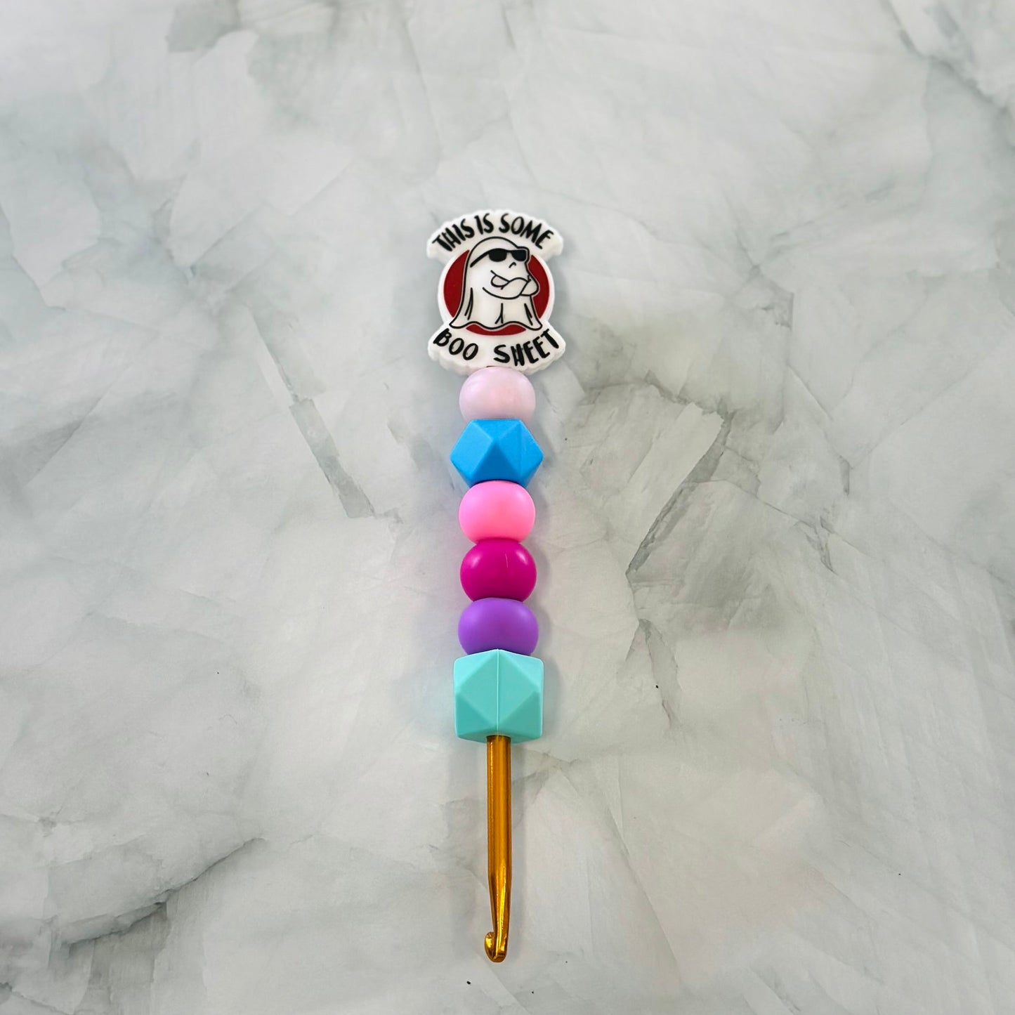 Crochet hook with colorful bead handle on a marble background chenille yarn plush yarn acrylic yarn 