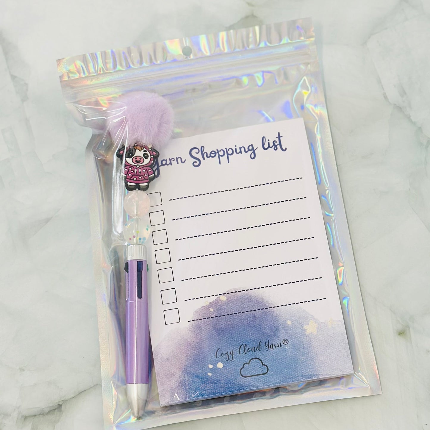 Notepad with pen and shopping list on a marble surface