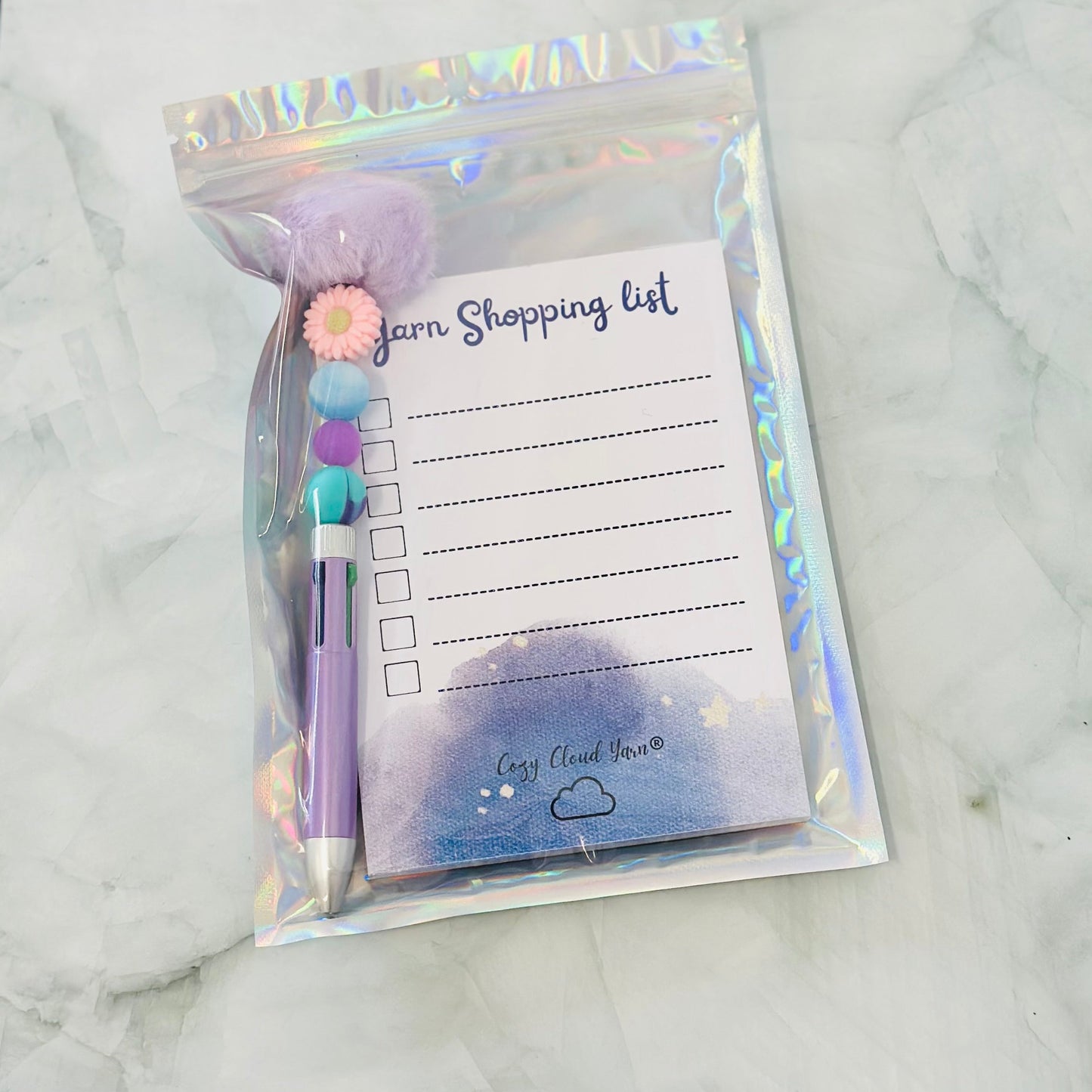Packaged item with a shopping list and pen on a marble surface
