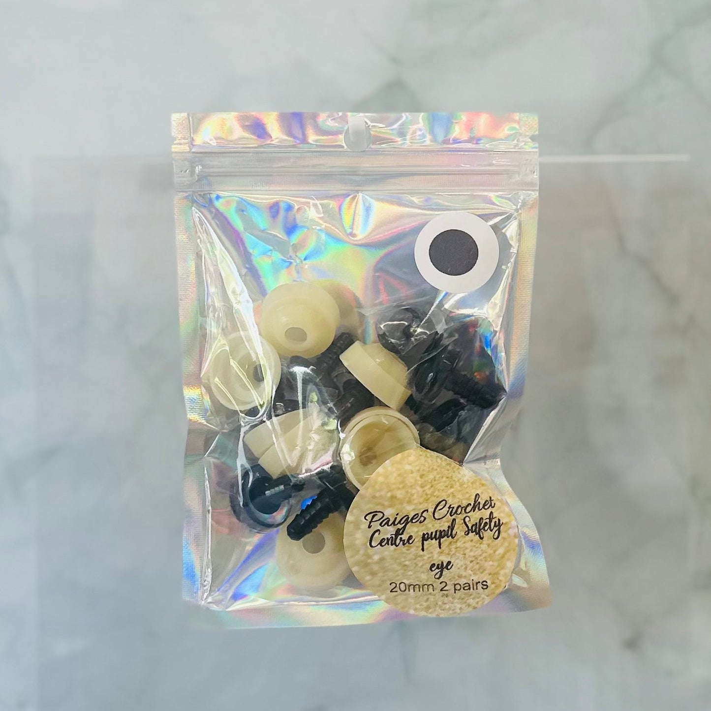 Packaged safety eyes with a holographic bag on a white background