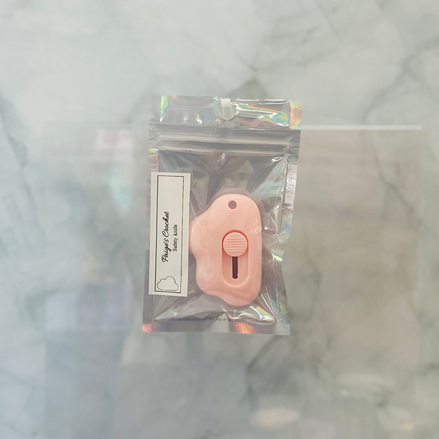 Pink butterfly knife in clear packaging on a marble background