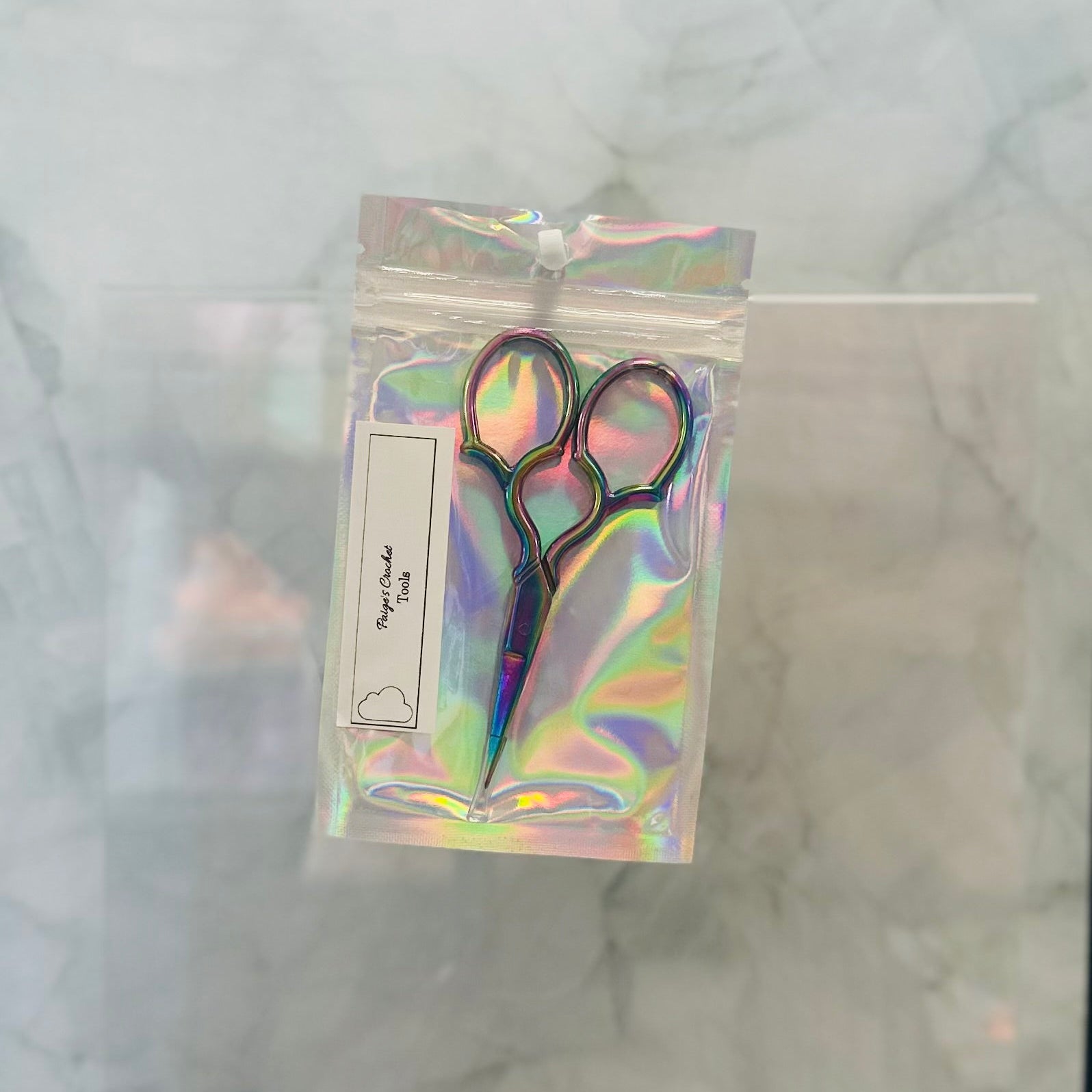 Holographic packaging with scissors on a marble surface