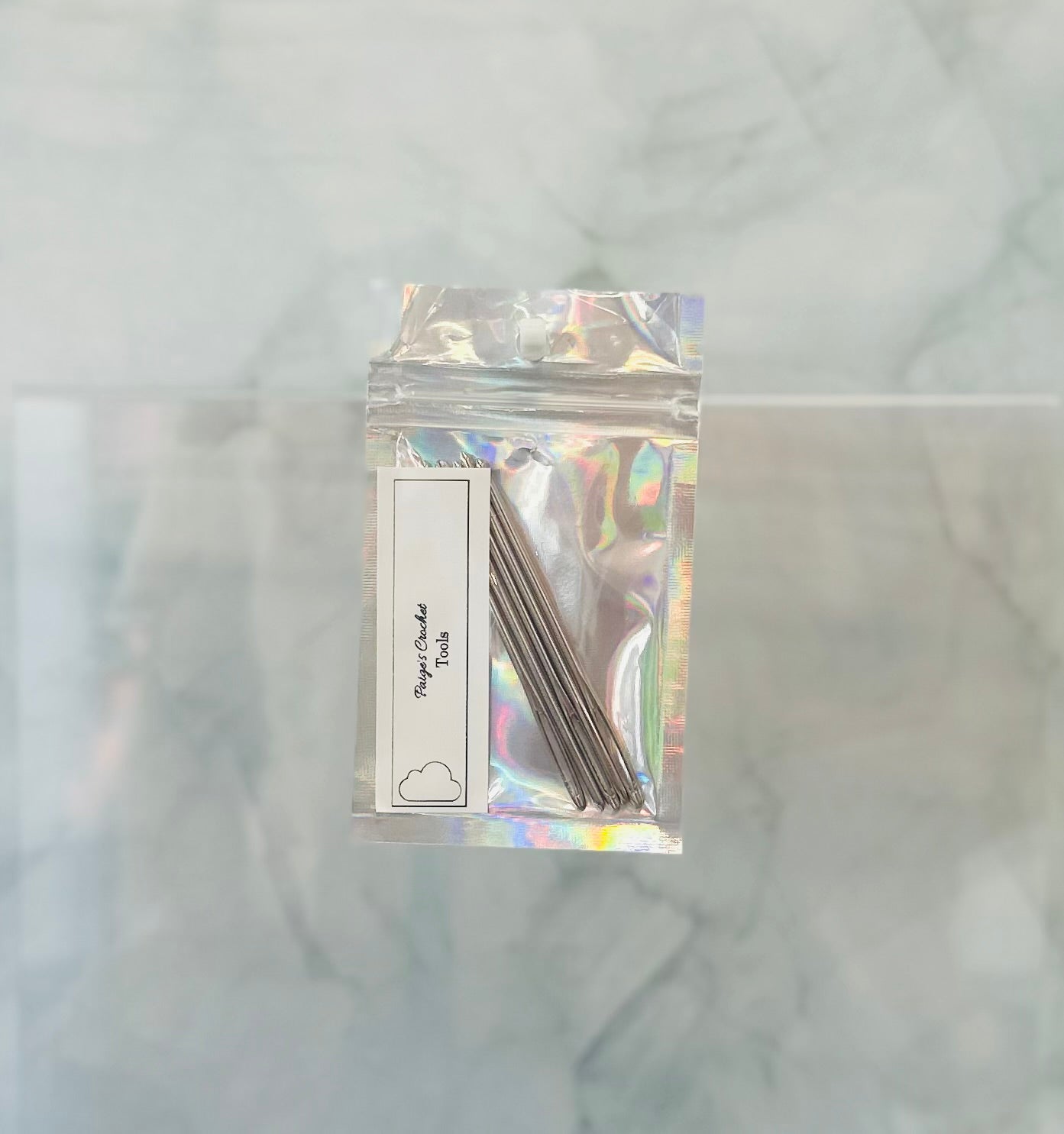 Holographic packaging with metal needles on a marble background