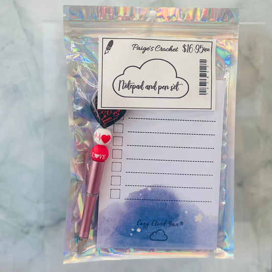 Notebook and pen set in clear packaging with a label on a marble surface