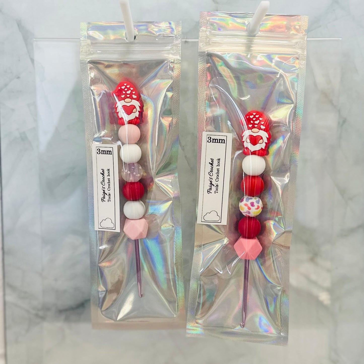 3mm crochet hooks with valentines day themed gnomes sitting on top 
