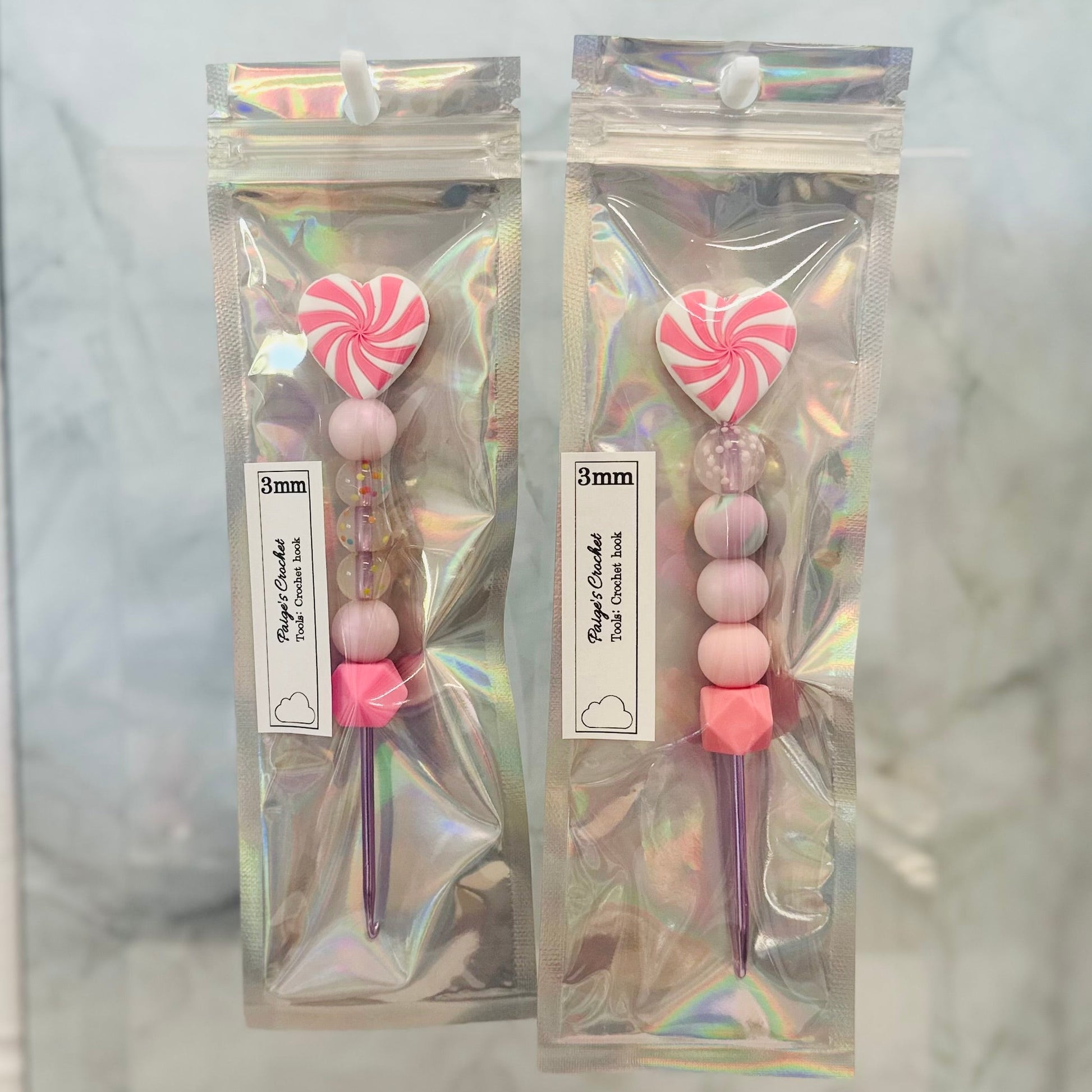 Two packages of decorative sticks with pink and white candy-like tops on a marble background