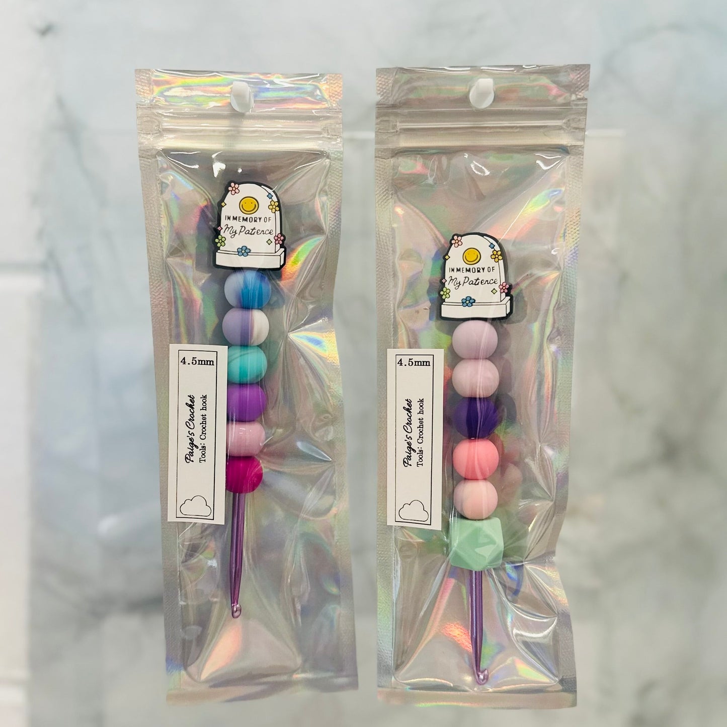 Two packages of colorful crochet hooks on a marble background