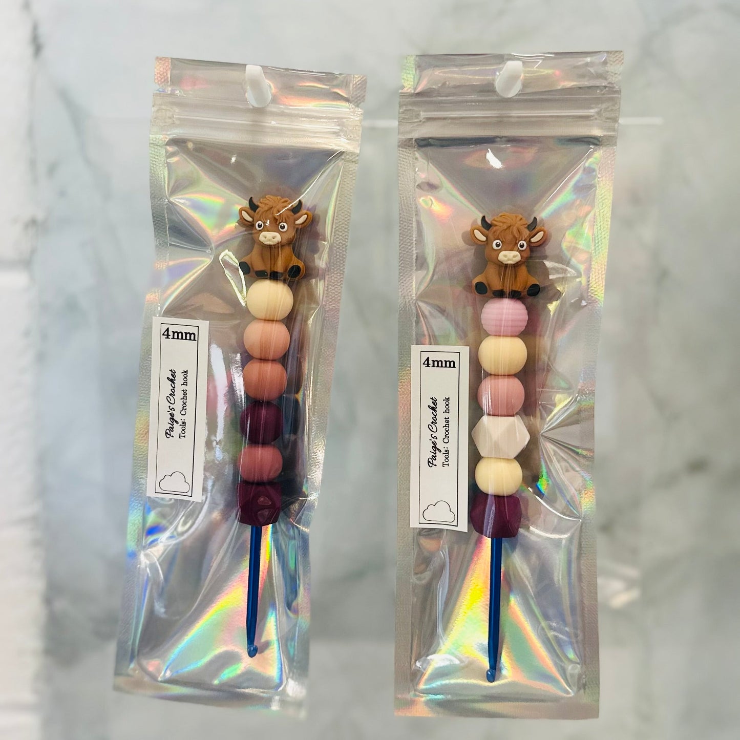 colourful beaded crochet hooks in 4mm with.a highland cow sitting on top 