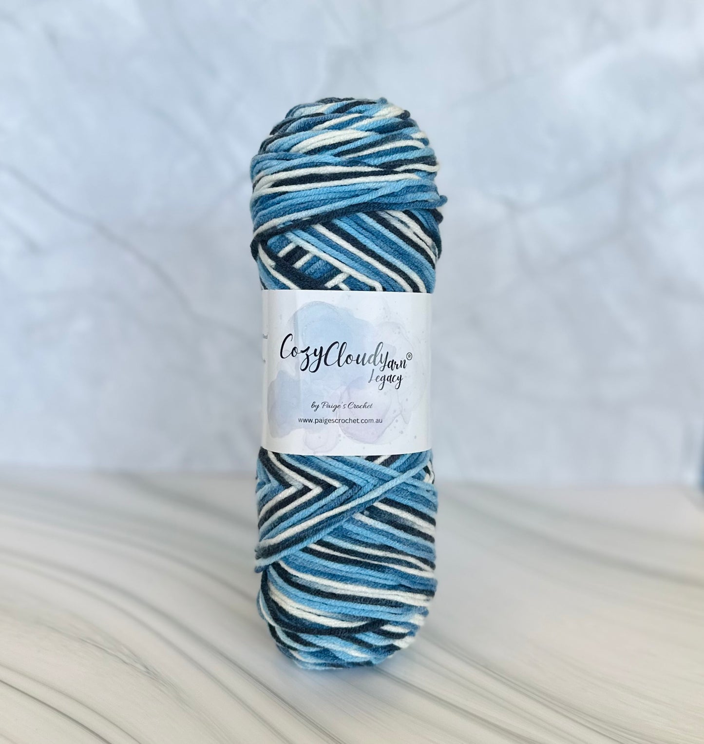 Blue and white striped yarn skein with a label on a light gray background