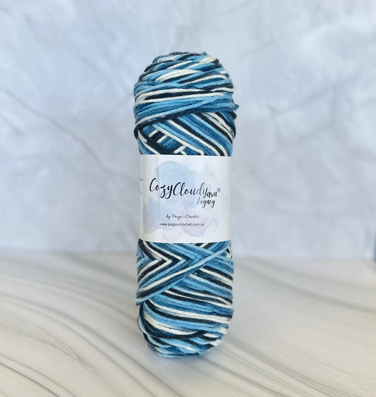 Blue and white striped yarn skein with a label on a light gray background