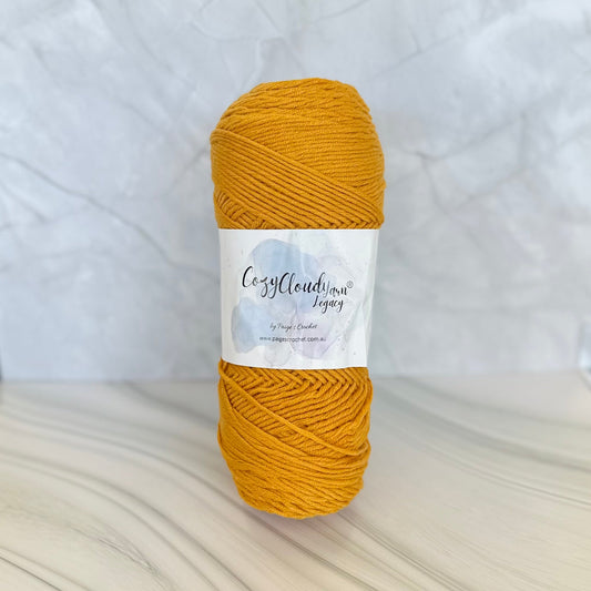 Mustard yellow yarn ball with a label on a white background