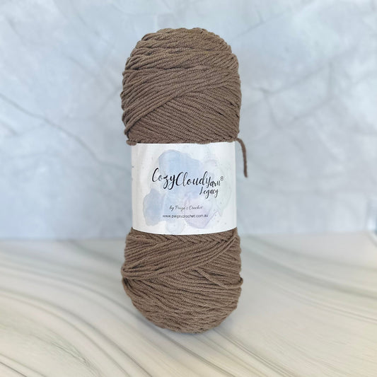 Ball of brown yarn with a label on a white background