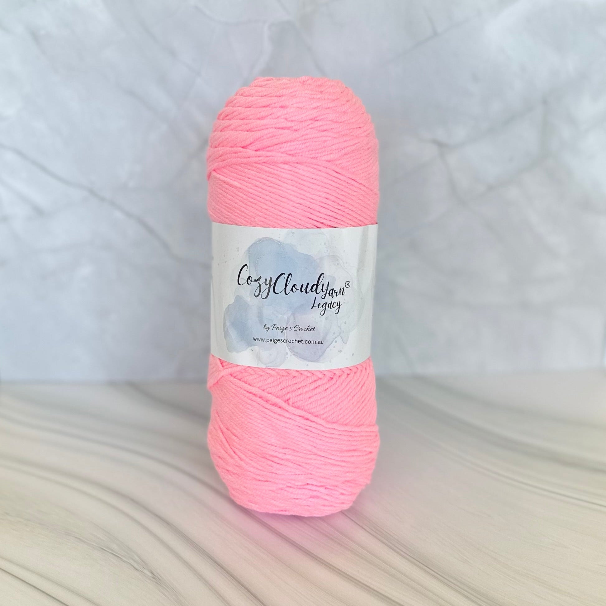Pink yarn ball with a label on a textured white background