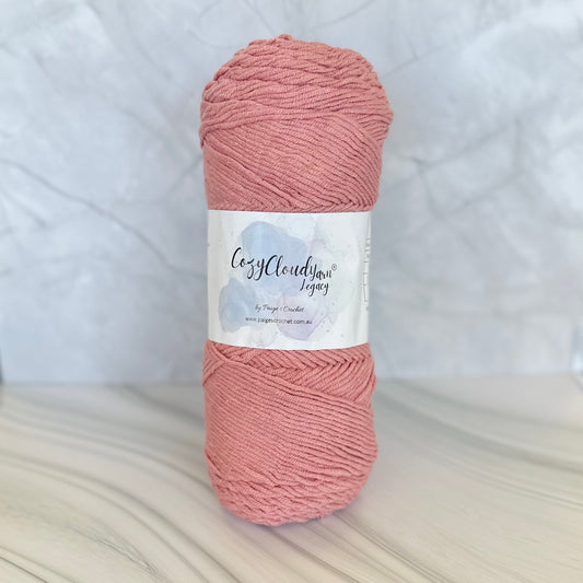 Ball of pink yarn with a label on a white background