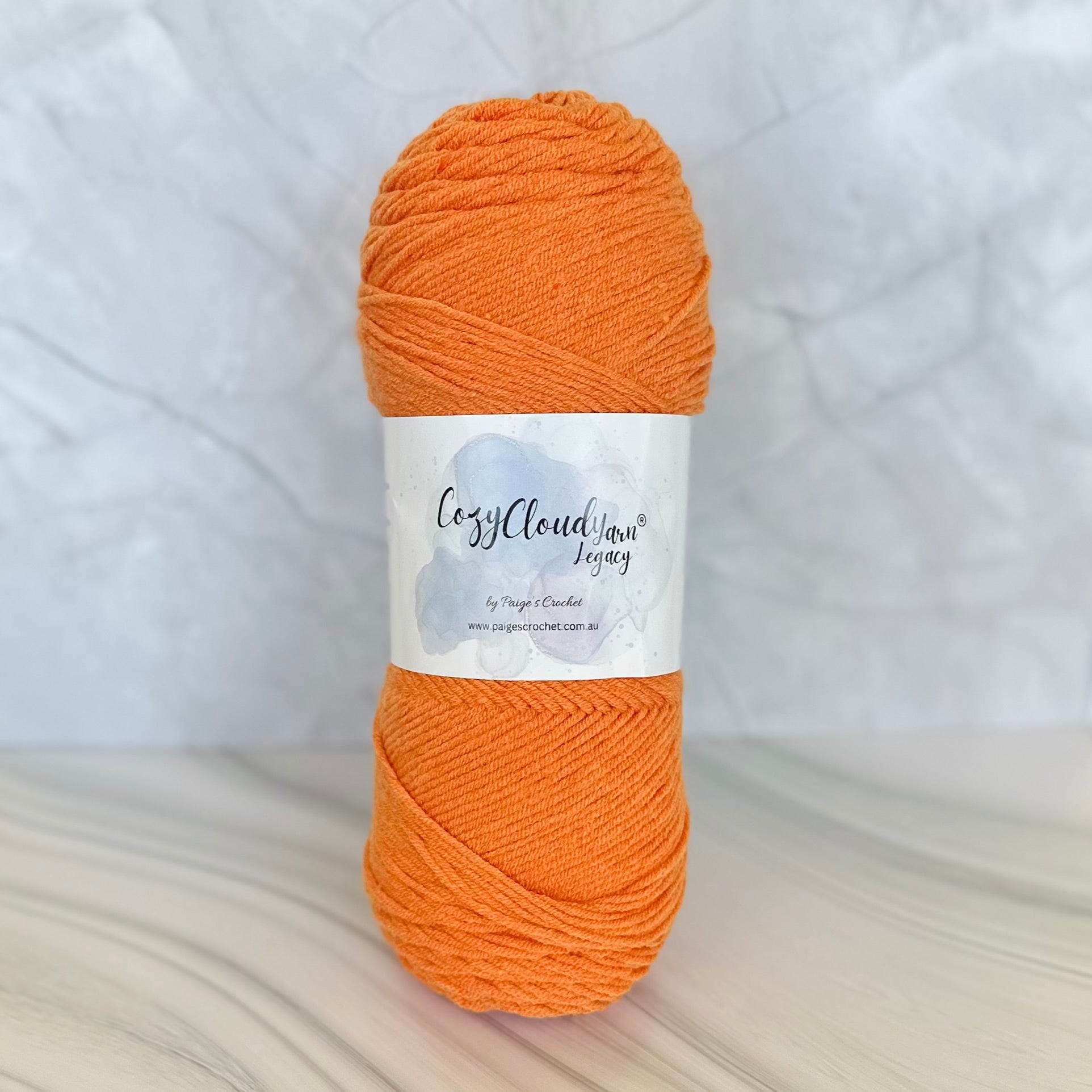 Ball of orange yarn with a label on a white background