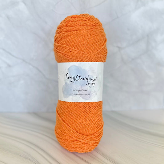 Ball of orange yarn with a label on a white background