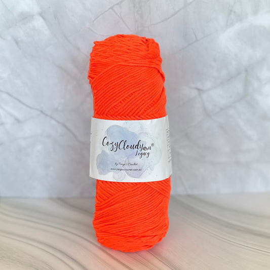 Ball of orange yarn with a label on a light gray background