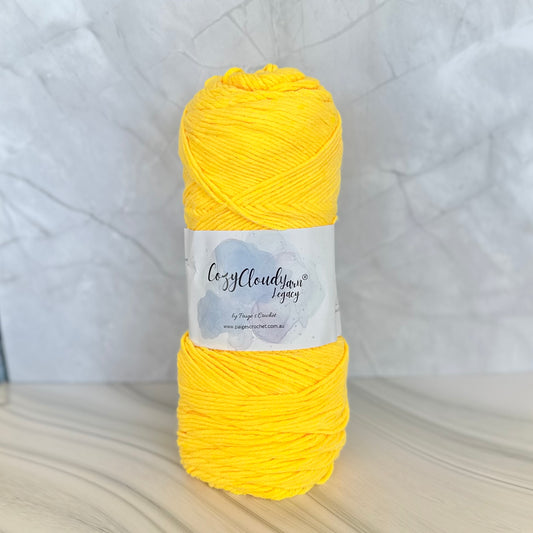 Yellow yarn ball with a label on a textured white background