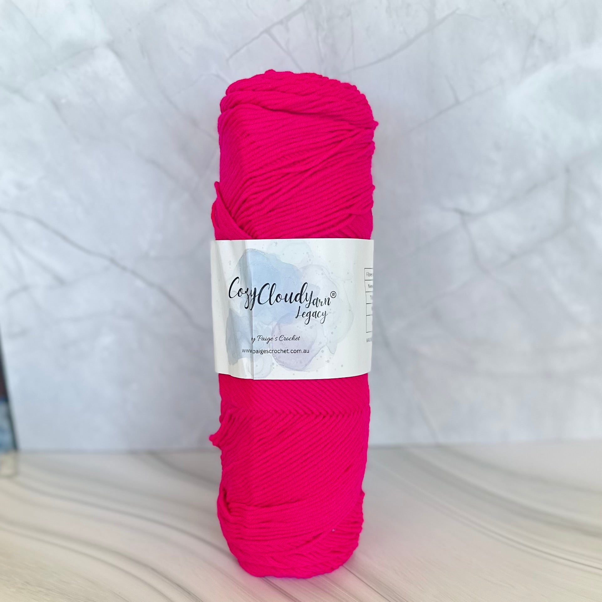 Ball of pink yarn with a label on a white background