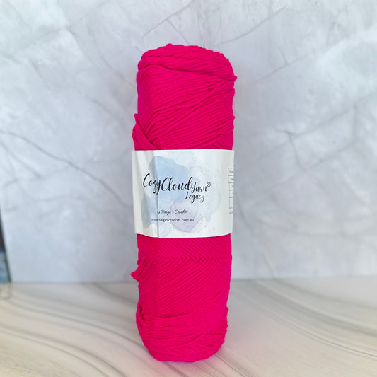 Ball of pink yarn with a label on a white background
