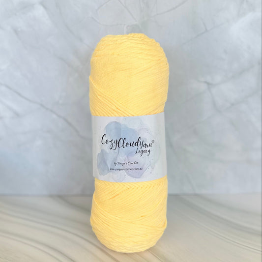 Yellow skein of yarn with a label on a textured surface