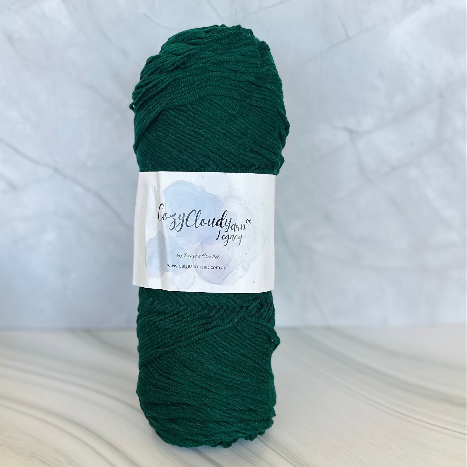 Dark green skein of yarn with a label on a light gray background