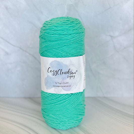 Turquoise skein of yarn with a label on a white background
