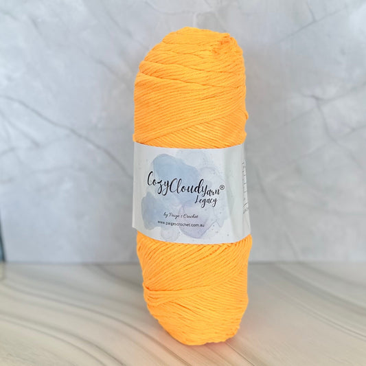Orange skein of yarn with a label on a light gray background