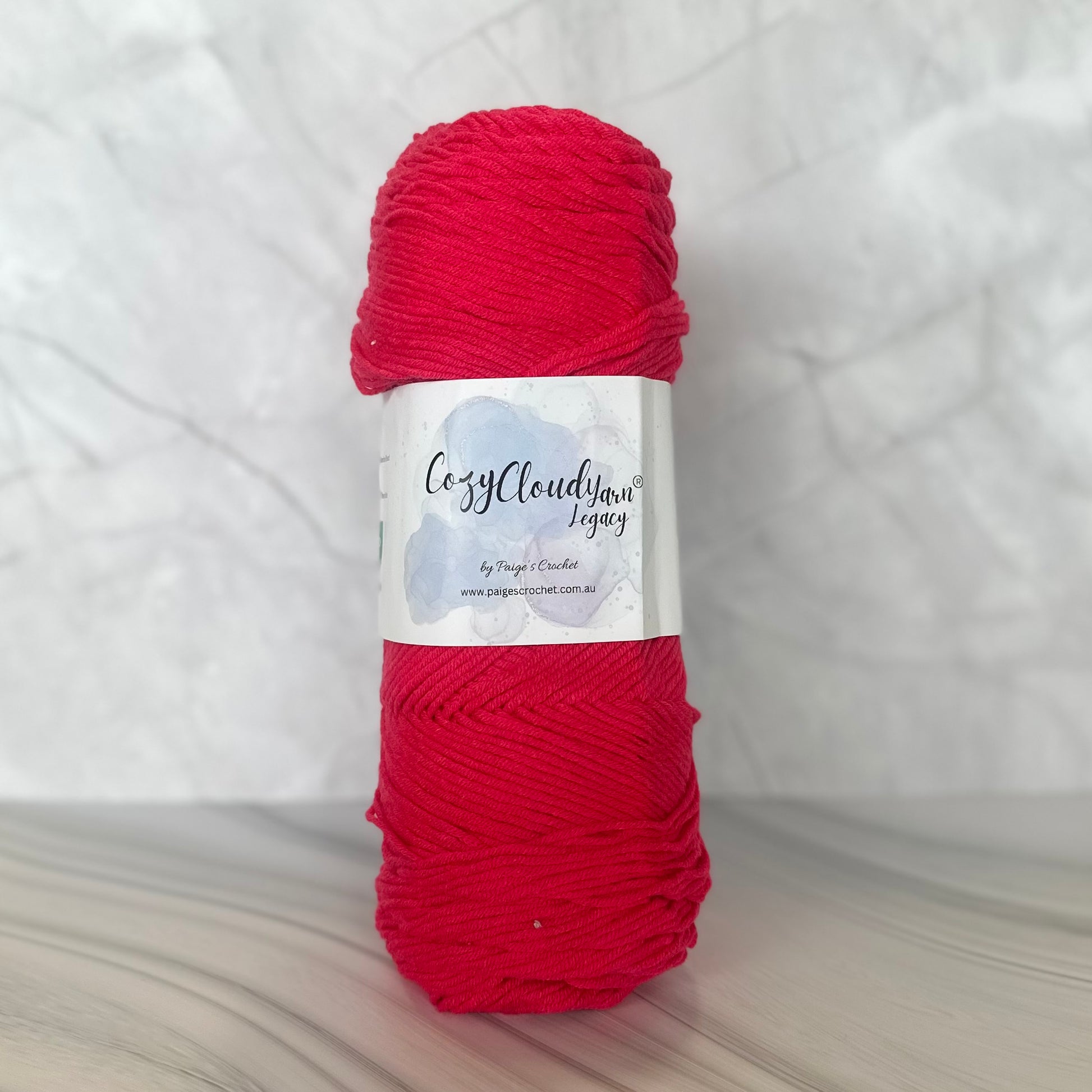 pink  skein of yarn with a label on a white background