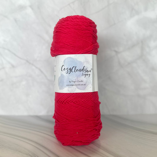pink  skein of yarn with a label on a white background